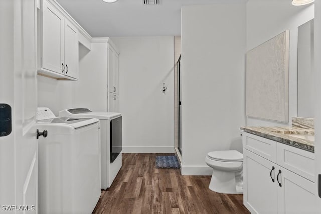 laundry area with dark wood-type flooring and washer and dryer