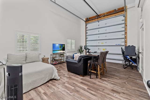 bedroom featuring hardwood / wood-style floors and a towering ceiling