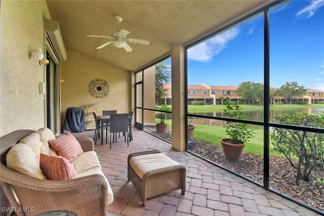 sunroom with a water view and ceiling fan