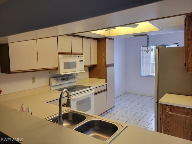 kitchen featuring sink, a chandelier, light tile patterned floors, pendant lighting, and white appliances