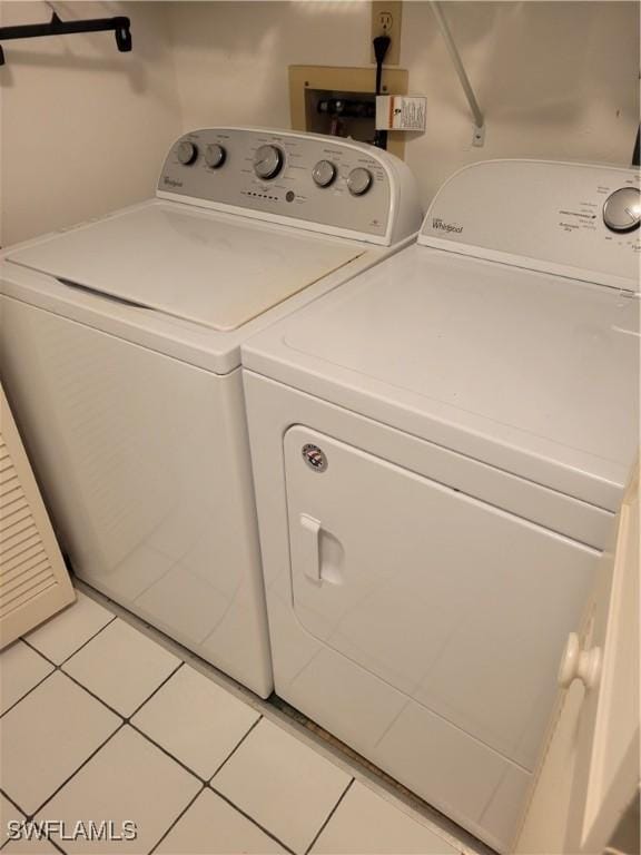 laundry room with washing machine and clothes dryer and tile patterned flooring