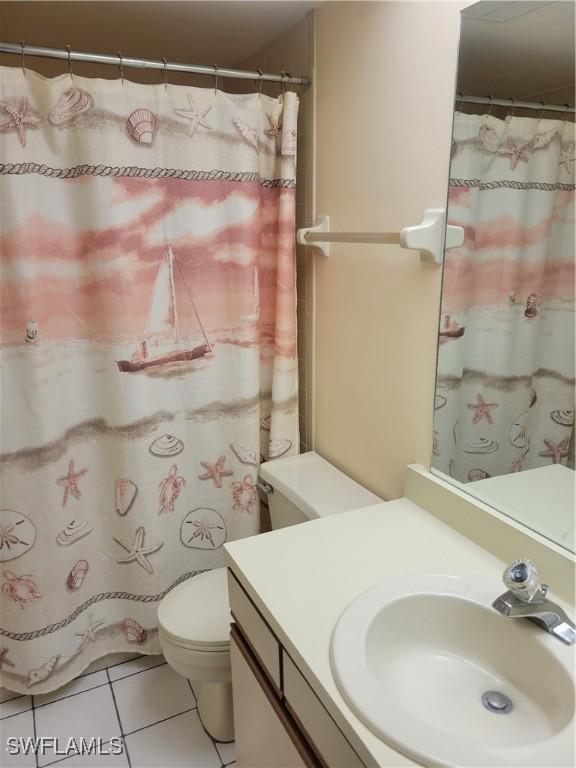 bathroom featuring vanity, tile patterned floors, and toilet