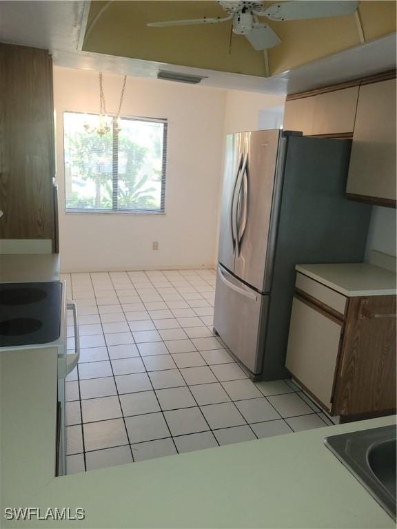 kitchen featuring light tile patterned floors, stainless steel fridge, and ceiling fan