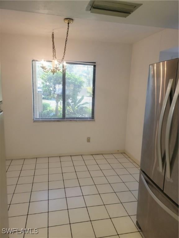 unfurnished dining area featuring an inviting chandelier