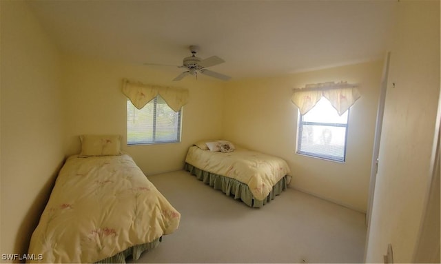 bedroom featuring multiple windows, carpet, and ceiling fan