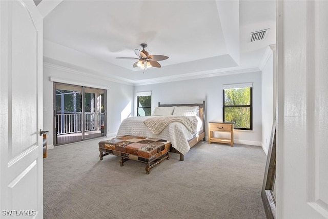 carpeted bedroom with a raised ceiling, ornamental molding, access to exterior, and ceiling fan