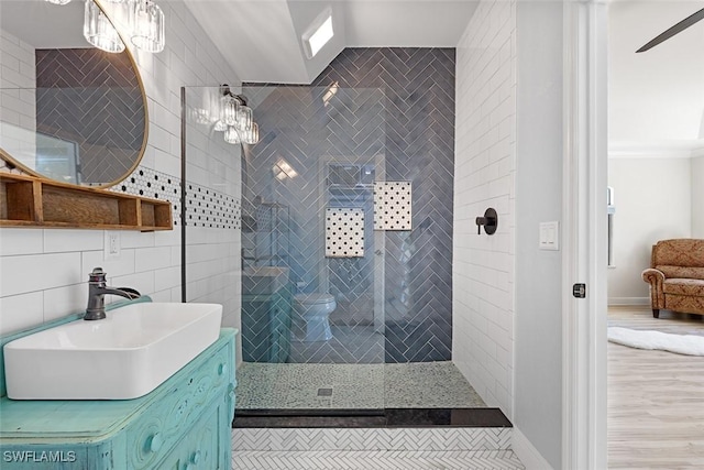 bathroom with tile walls, vanity, tasteful backsplash, and tiled shower