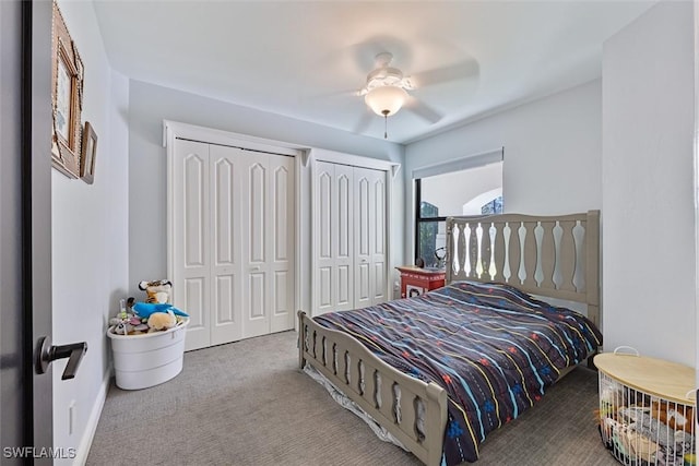 bedroom with ceiling fan, carpet floors, and two closets