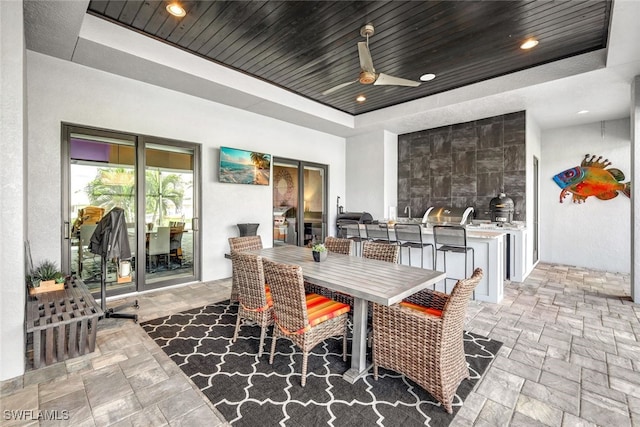 view of patio with exterior bar, an outdoor kitchen, and ceiling fan