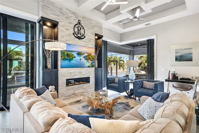 living room with beamed ceiling, ceiling fan, coffered ceiling, and a tile fireplace