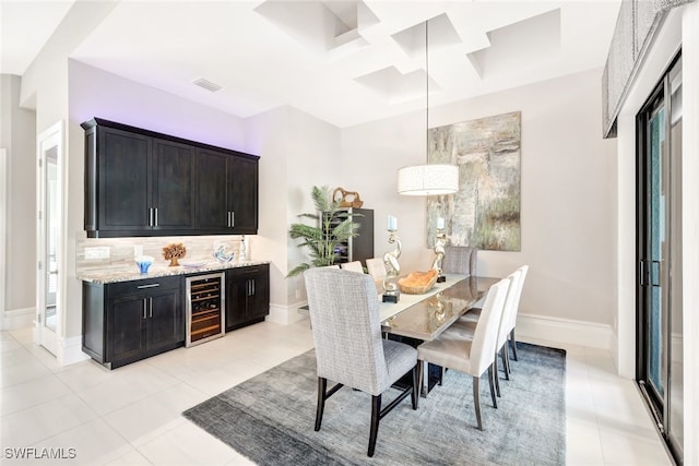 dining space featuring wine cooler, coffered ceiling, and light tile patterned flooring