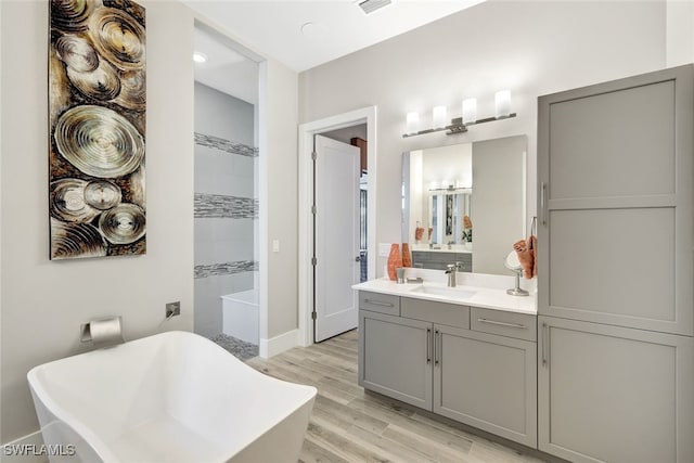 bathroom featuring vanity, hardwood / wood-style flooring, and separate shower and tub