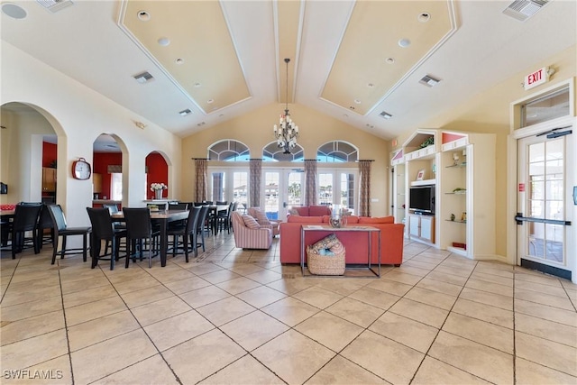 tiled living room with french doors, vaulted ceiling, and built in shelves