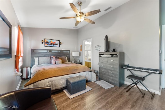 bedroom with hardwood / wood-style flooring, ceiling fan, radiator, and vaulted ceiling