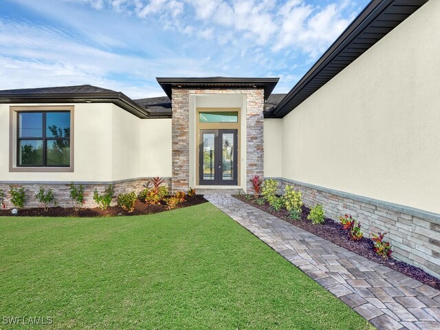 entrance to property with french doors and a yard