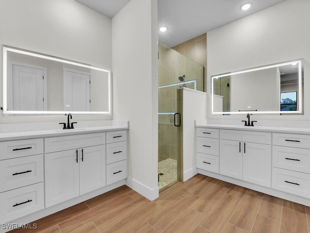 bathroom featuring vanity and a shower with door