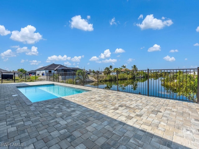 view of swimming pool featuring a patio, a water view, fence, and a fenced in pool