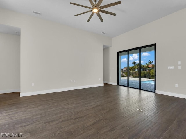 empty room with dark wood-style floors, baseboards, visible vents, and a ceiling fan