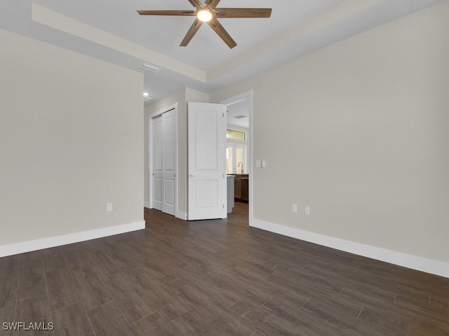 spare room with visible vents, baseboards, dark wood finished floors, and a ceiling fan