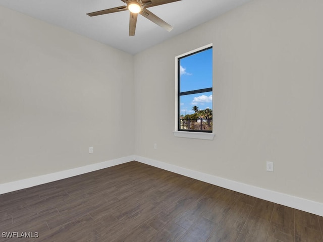 unfurnished room with dark wood-style floors, a ceiling fan, and baseboards