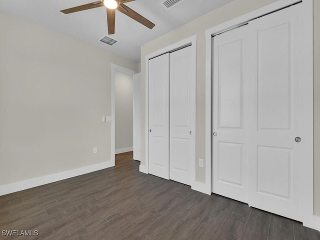 unfurnished bedroom with ceiling fan, dark wood-style flooring, visible vents, and baseboards