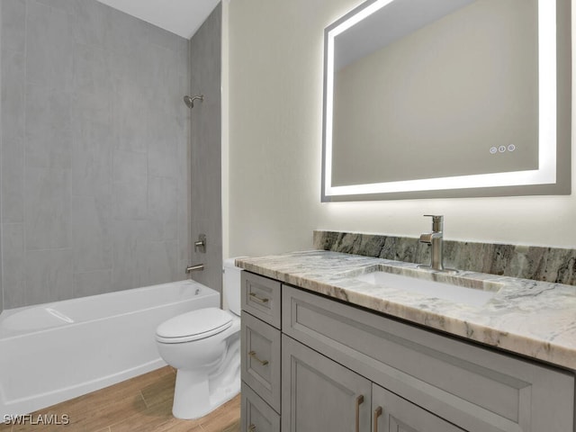 bathroom with vanity, bathing tub / shower combination, wood finished floors, and toilet