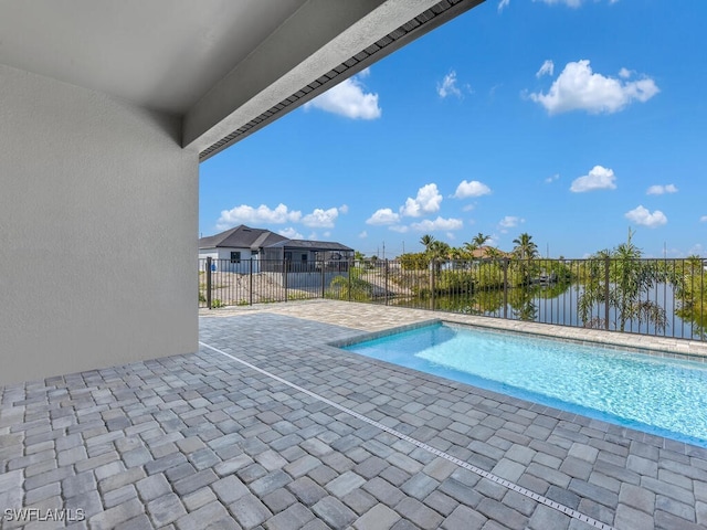 view of pool featuring a patio area, fence, a fenced in pool, and a water view