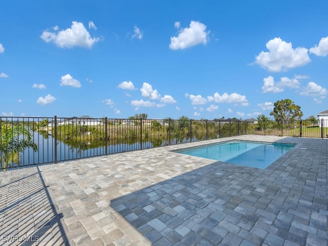 view of pool featuring a water view, a patio area, fence, and a fenced in pool