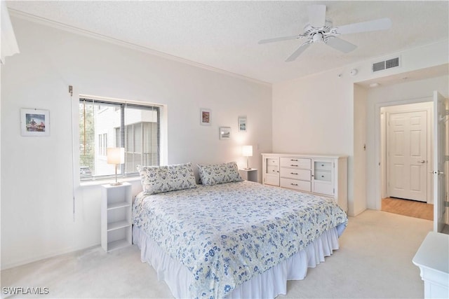 bedroom featuring light carpet, a textured ceiling, and ceiling fan