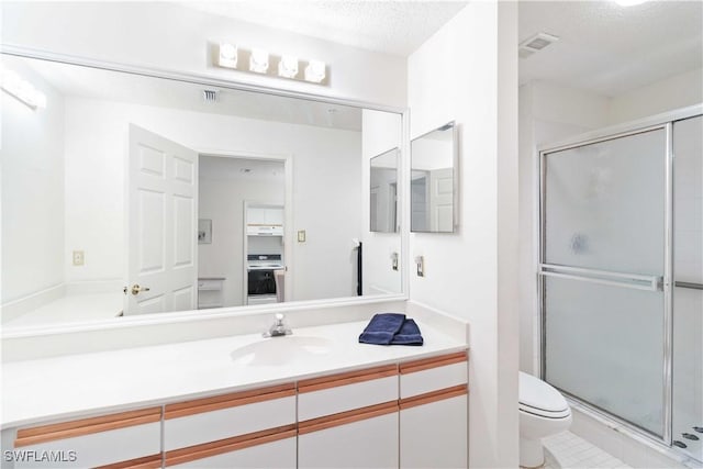 bathroom featuring vanity, toilet, an enclosed shower, and a textured ceiling