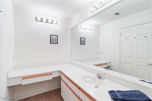 bathroom with vanity, hardwood / wood-style floors, and a textured ceiling