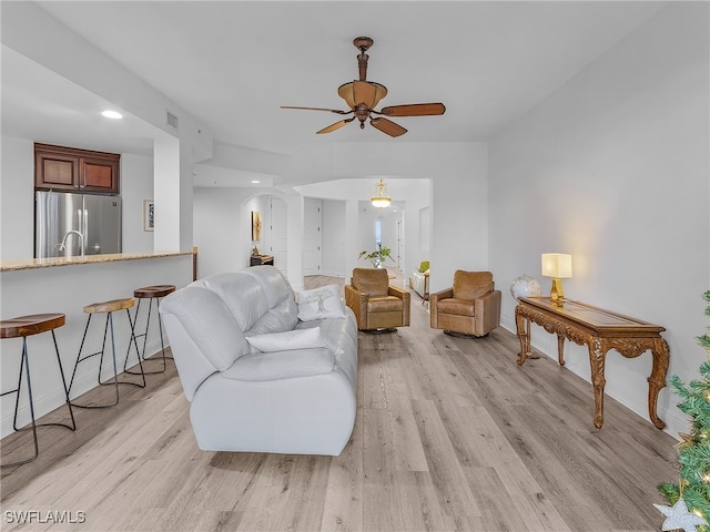 living room with light hardwood / wood-style flooring and ceiling fan