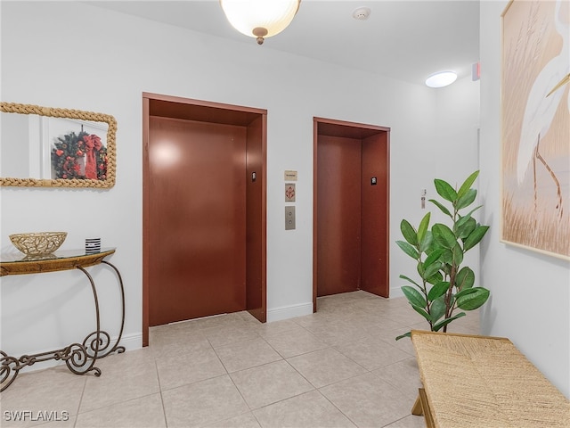 hall with elevator and light tile patterned floors