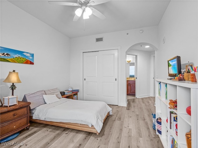 bedroom featuring ceiling fan, connected bathroom, and light wood-type flooring