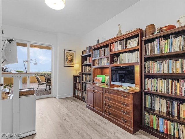 home office with light hardwood / wood-style flooring