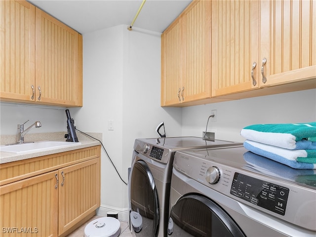 washroom with cabinets, sink, and independent washer and dryer