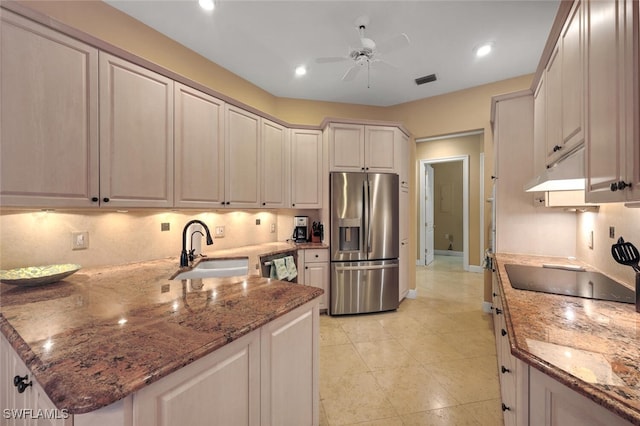 kitchen with stainless steel appliances, sink, stone counters, and ceiling fan