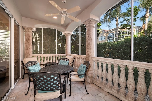 sunroom with decorative columns and ceiling fan