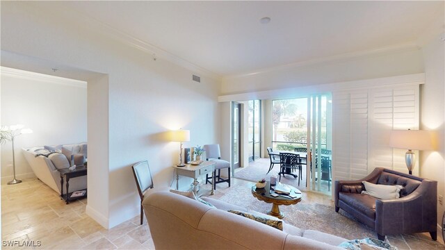 living area featuring baseboards, visible vents, and ornamental molding