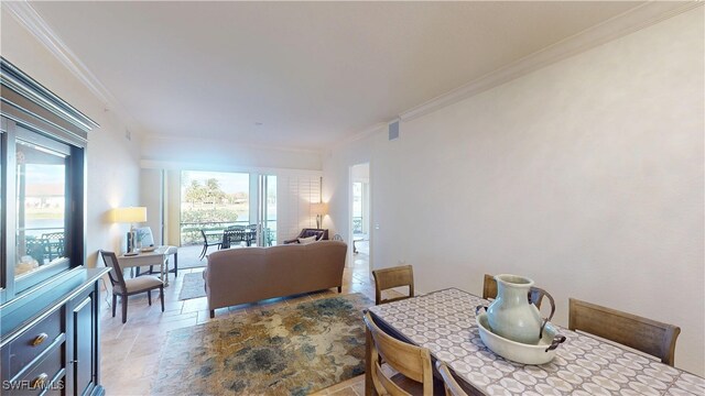 dining space with a wealth of natural light, visible vents, crown molding, and stone finish flooring