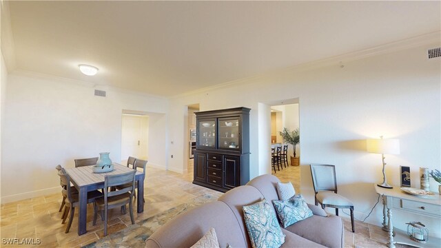 living area with visible vents, crown molding, and baseboards