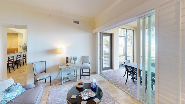 living room with visible vents, baseboards, and crown molding