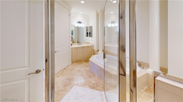 bathroom featuring a garden tub, decorative columns, recessed lighting, stone tile flooring, and vanity