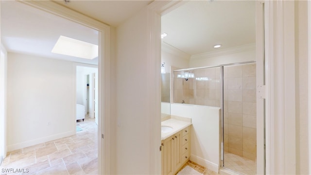 full bath featuring baseboards, vanity, a skylight, and a shower stall