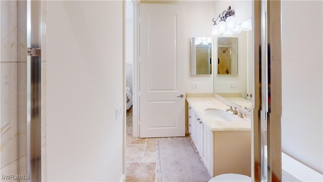 bathroom featuring stone finish flooring and vanity