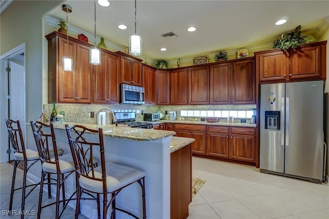 kitchen with kitchen peninsula, pendant lighting, stainless steel appliances, light stone countertops, and decorative backsplash