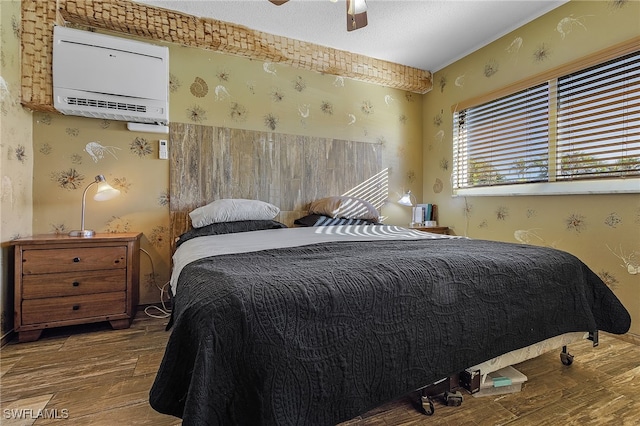 bedroom featuring wood-type flooring, an AC wall unit, and ceiling fan