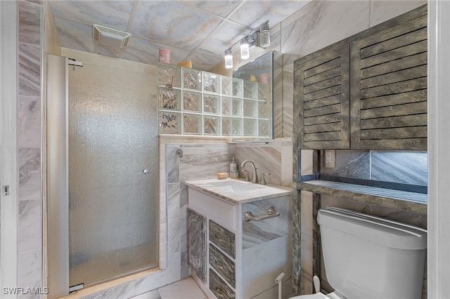 bathroom with tile walls, vanity, and toilet