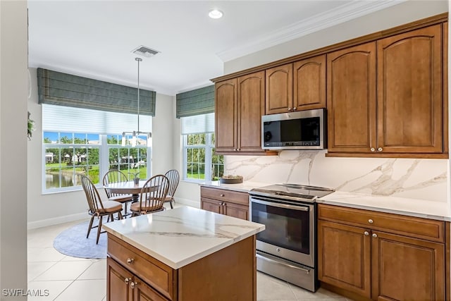 kitchen with light tile patterned flooring, decorative light fixtures, ornamental molding, appliances with stainless steel finishes, and decorative backsplash