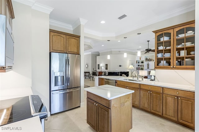 kitchen featuring sink, crown molding, light tile patterned floors, stainless steel appliances, and a center island